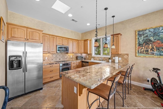 kitchen featuring a breakfast bar area, hanging light fixtures, kitchen peninsula, stainless steel appliances, and light stone countertops