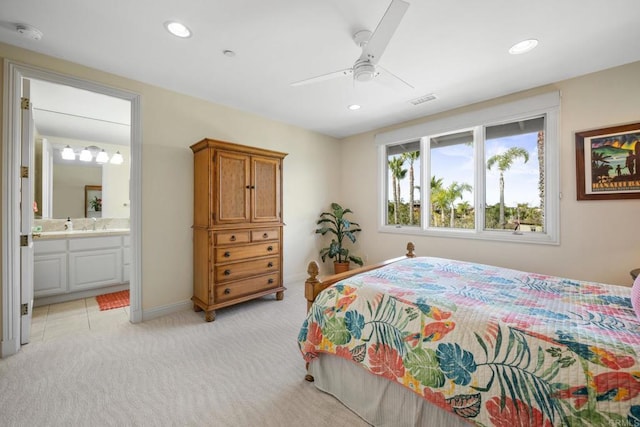 bedroom featuring ensuite bathroom, light carpet, and ceiling fan