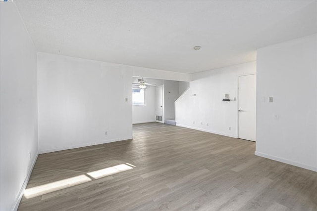 empty room with wood-type flooring and ceiling fan