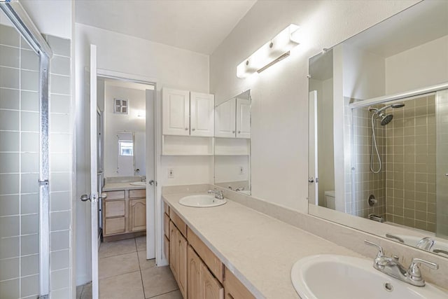 full bathroom featuring tiled shower / bath combo, vanity, tile patterned floors, and toilet