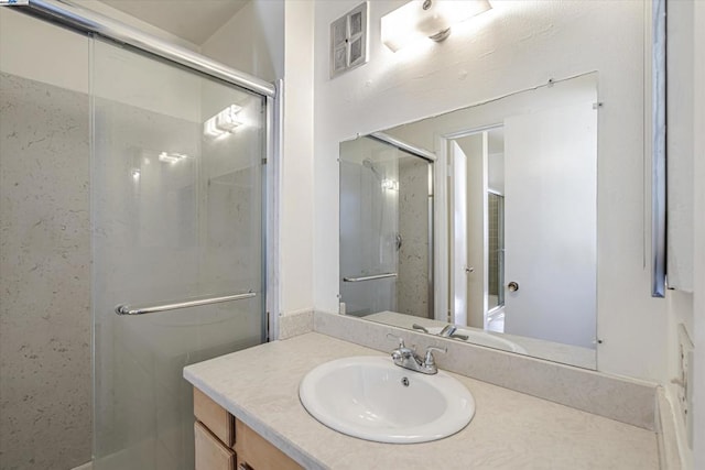 bathroom with vanity and a shower with shower door