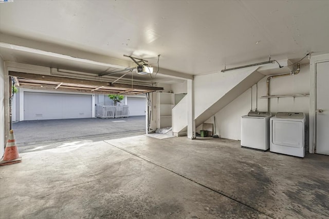 garage with a garage door opener and independent washer and dryer