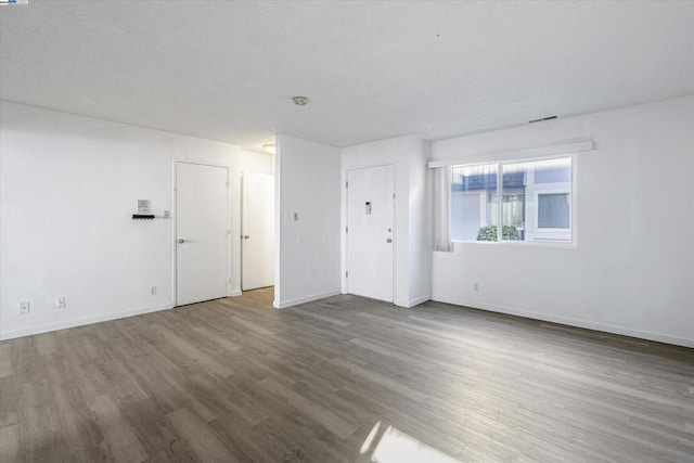 empty room with dark hardwood / wood-style flooring