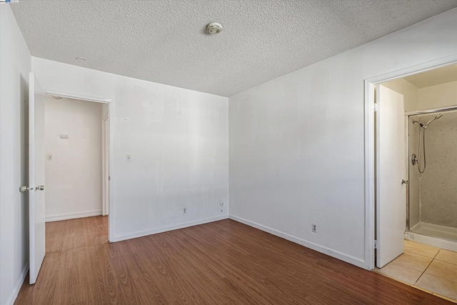 unfurnished bedroom featuring hardwood / wood-style flooring and a textured ceiling