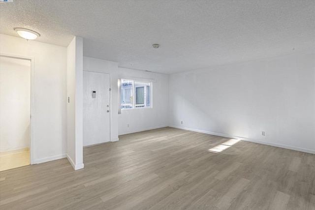 entrance foyer with light hardwood / wood-style floors and a textured ceiling