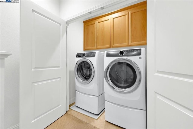 laundry room with cabinets, separate washer and dryer, and light tile patterned floors