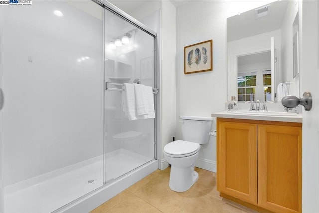 bathroom with tile patterned flooring, vanity, toilet, and walk in shower