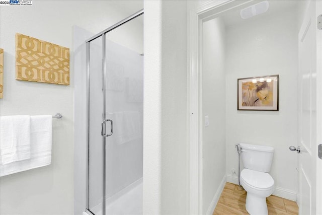 bathroom with toilet and a shower with door