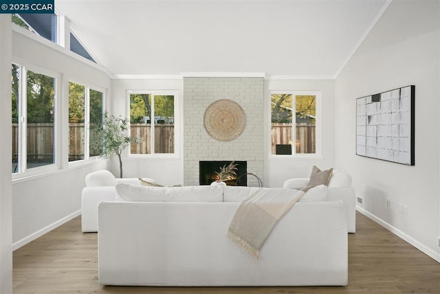 living room with hardwood / wood-style flooring, lofted ceiling, and a fireplace