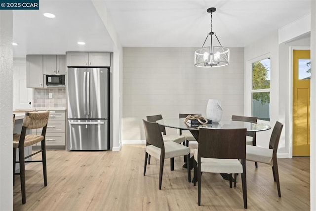 dining area with a notable chandelier and light wood-type flooring