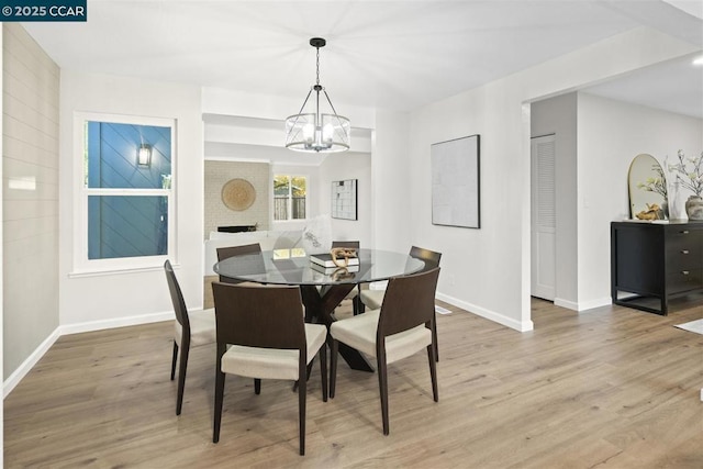 dining space featuring a brick fireplace, wood-type flooring, and a chandelier