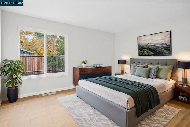 bedroom with light hardwood / wood-style floors and multiple windows