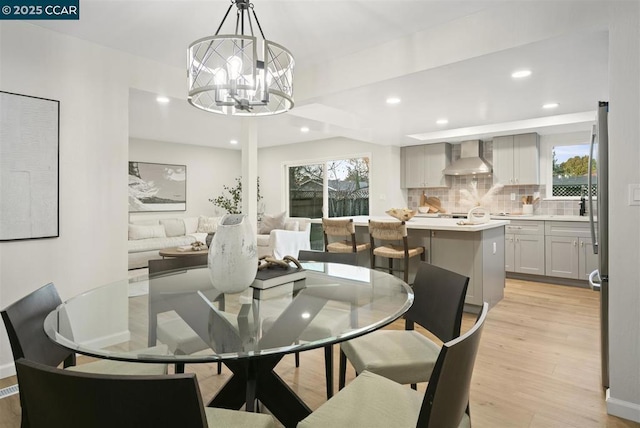 dining space with light hardwood / wood-style flooring and a notable chandelier