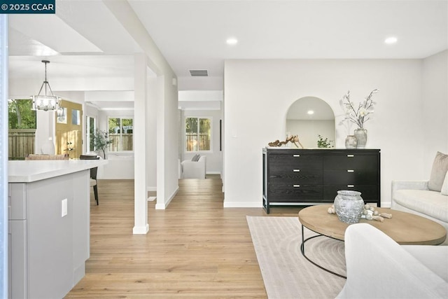 living room with light hardwood / wood-style flooring and a notable chandelier