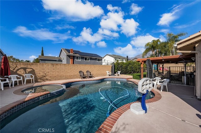 view of pool with a patio area and an in ground hot tub