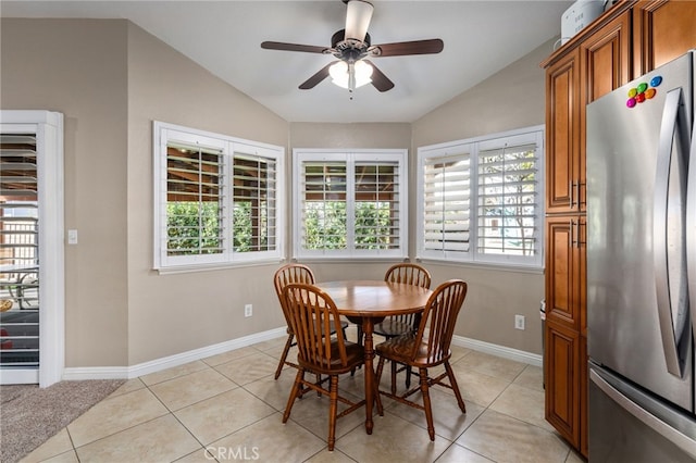 dining space featuring light tile patterned flooring, ceiling fan, and vaulted ceiling