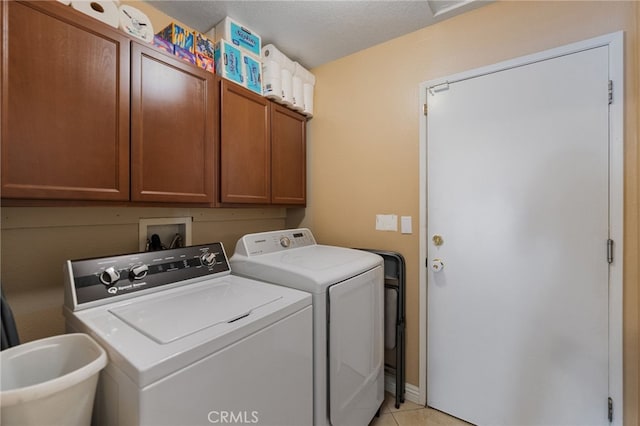 washroom featuring light tile patterned flooring, cabinets, washer and clothes dryer, and sink