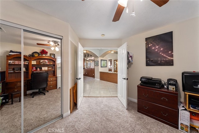 bedroom with ceiling fan, light colored carpet, and a closet