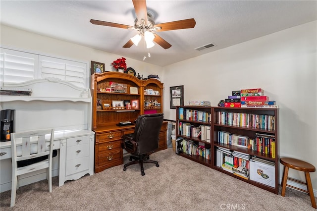 carpeted home office with ceiling fan