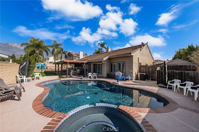 view of swimming pool featuring an in ground hot tub and a patio