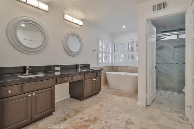 bathroom with vanity and shower with separate bathtub