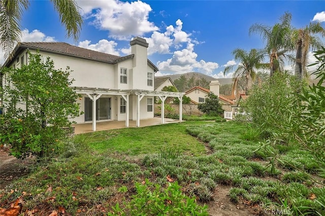 rear view of house with a yard, a patio area, and a pergola