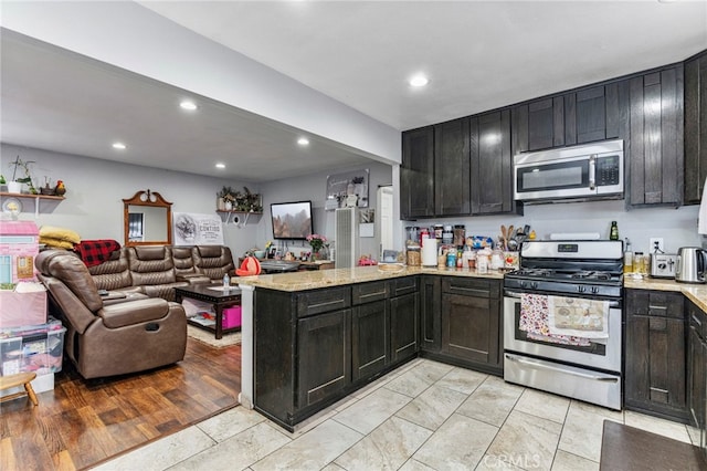 kitchen featuring light stone counters, kitchen peninsula, and appliances with stainless steel finishes