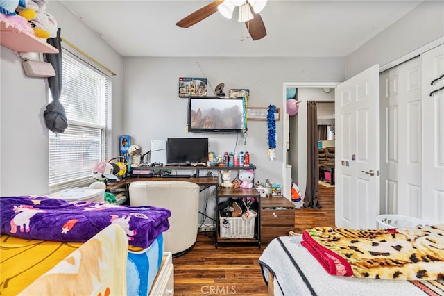 bedroom with dark wood-type flooring, ceiling fan, and a closet