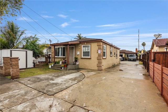 back of house featuring a storage unit