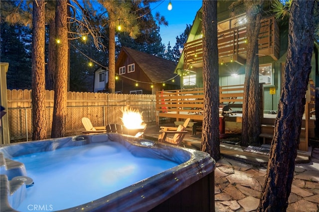 view of patio / terrace featuring a hot tub and a fire pit