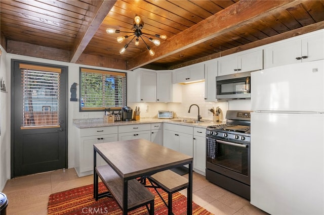 kitchen featuring white refrigerator, black range with gas cooktop, and white cabinets