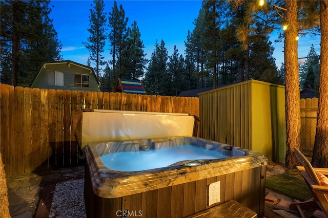 yard at dusk featuring a hot tub