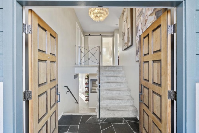 entrance foyer featuring a barn door and a notable chandelier