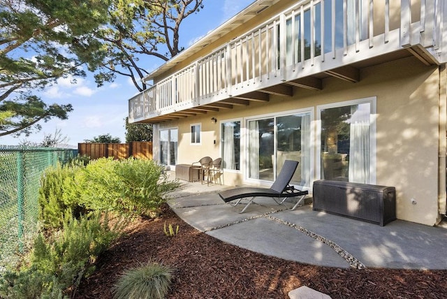 rear view of house featuring a patio and a balcony