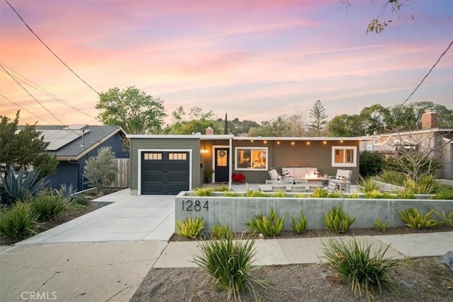 view of front of house with a garage and an outdoor living space