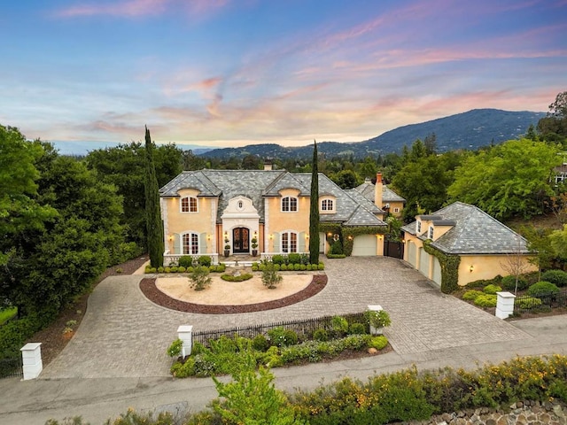 french provincial home featuring a garage and a mountain view