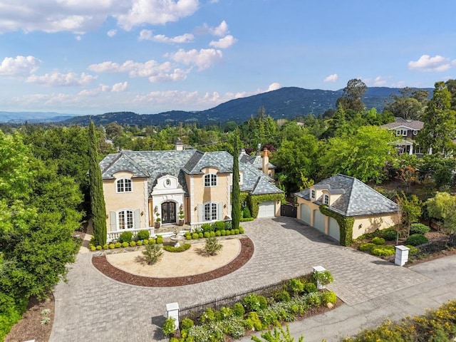 french country style house featuring a garage and a mountain view