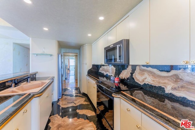 kitchen featuring white cabinetry, black range with electric stovetop, sink, and tasteful backsplash