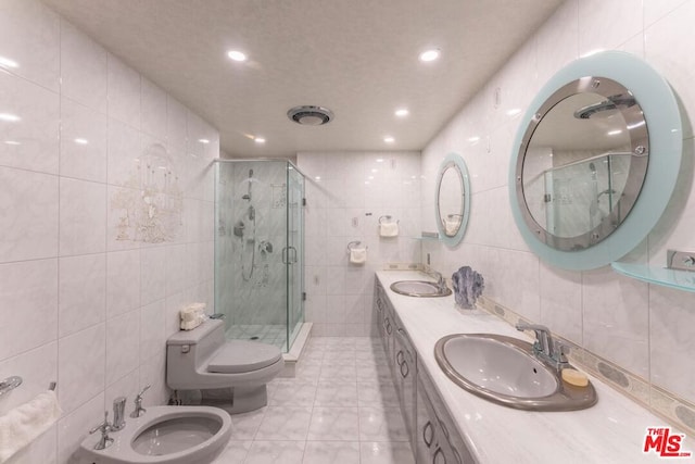 bathroom with tile walls, an enclosed shower, vanity, and a bidet