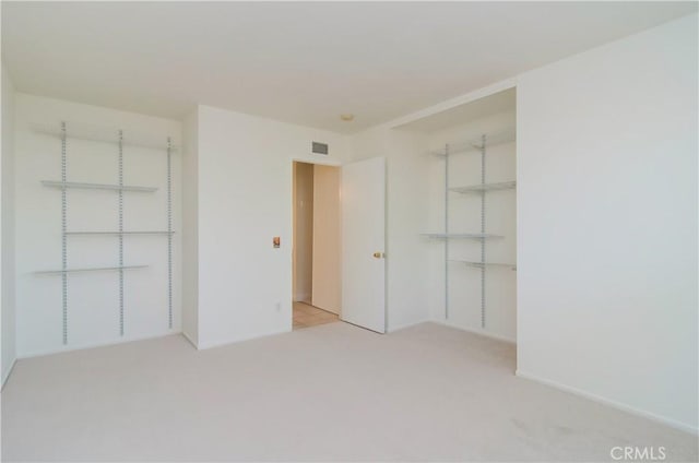 unfurnished bedroom featuring light colored carpet and a closet