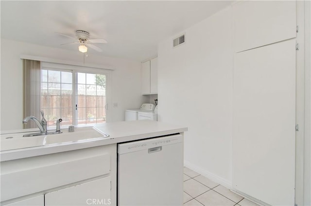 kitchen featuring sink, light tile patterned floors, dishwasher, white cabinetry, and separate washer and dryer