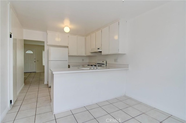 kitchen with white cabinetry, sink, white fridge, light tile patterned floors, and kitchen peninsula