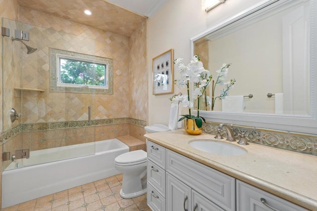 full bathroom featuring tiled shower / bath, vanity, and toilet