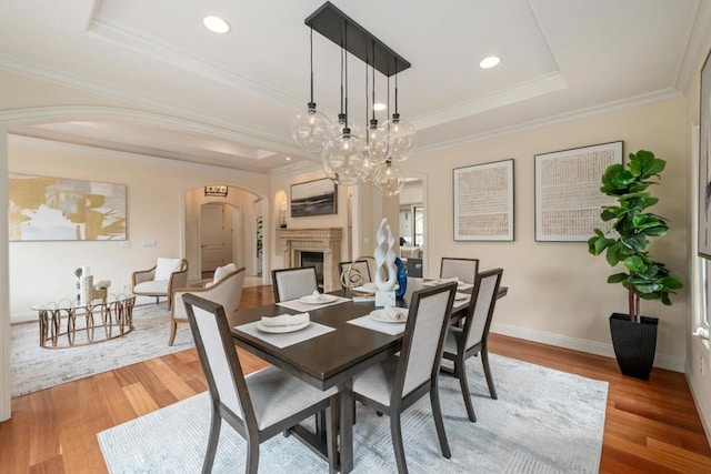 dining room featuring ornamental molding, wood-type flooring, and a tray ceiling