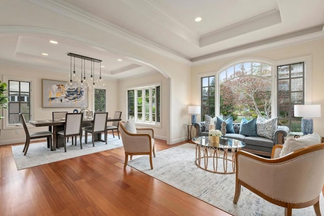 interior space with ornamental molding, a tray ceiling, and light hardwood / wood-style floors