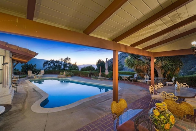 pool at dusk with a patio