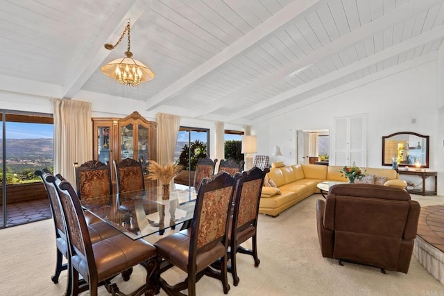 carpeted dining area featuring lofted ceiling with beams, a wealth of natural light, and a notable chandelier