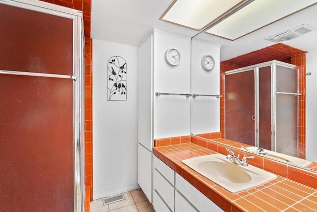 bathroom featuring tile patterned flooring, vanity, and walk in shower