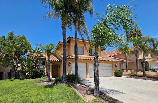 mediterranean / spanish house featuring a garage and a front yard