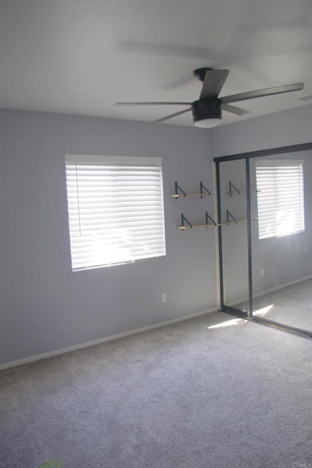 unfurnished bedroom with carpet floors, a closet, and ceiling fan